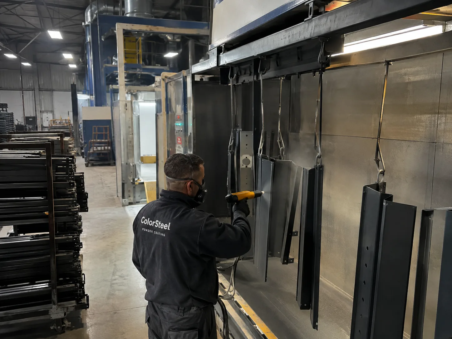 Angajat ColorSteel aplică vopsea pulbere pe profile în cameră